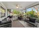 Enclosed patio with comfortable seating, ceiling fan, and view of a beautifully landscaped backyard at 8083 Bayhaven Dr, Seminole, FL 33776