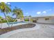 Landscaped backyard with a pool, covered patio, and lush tropical foliage at 1029 Bal Harbour Dr, Apollo Beach, FL 33572
