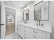 Modern bathroom with double vanity, stone countertop, decorative mirrors, and tile floor at 1029 Bal Harbour Dr, Apollo Beach, FL 33572