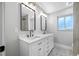 Bathroom with dual sinks, white cabinets, modern fixtures, and decorative tile flooring at 1029 Bal Harbour Dr, Apollo Beach, FL 33572
