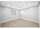 Bright bedroom features neutral paint, wood-look floors, window, ceiling fan, and closet at 1029 Bal Harbour Dr, Apollo Beach, FL 33572