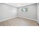 Well-lit bedroom with wood-look floors, window, and closet at 1029 Bal Harbour Dr, Apollo Beach, FL 33572