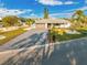 An exterior shot of a single-story house featuring a stone paver driveway and well-manicured landscaping at 1029 Bal Harbour Dr, Apollo Beach, FL 33572