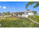 Exterior shot of a single-story home featuring lovely landscaping, an inviting front porch, and a lush green lawn at 1029 Bal Harbour Dr, Apollo Beach, FL 33572