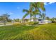 An exterior shot of the home shows the green grass, shrubbery, and palm trees in its landscaping at 1029 Bal Harbour Dr, Apollo Beach, FL 33572