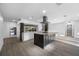 Spacious open-concept kitchen with a central island, white cabinetry, stainless steel appliances, and wood-style flooring at 1029 Bal Harbour Dr, Apollo Beach, FL 33572