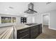 Bright kitchen featuring a central island with a cooktop and a modern range hood, enhancing the room's functionality at 1029 Bal Harbour Dr, Apollo Beach, FL 33572