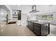 Modern kitchen island with a sleek cooktop and ample drawer space, complemented by stainless steel hood and pendant lighting at 1029 Bal Harbour Dr, Apollo Beach, FL 33572