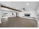 Open-concept living room with wood beam accents, a modern fireplace, and hardwood floors at 1029 Bal Harbour Dr, Apollo Beach, FL 33572