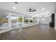 Bright living room with hardwood floors, a ceiling fan, and sliding glass doors to the outdoor pool area at 1029 Bal Harbour Dr, Apollo Beach, FL 33572