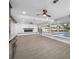 Spacious living room featuring a modern fireplace, hardwood floors, and views of the outdoor pool at 1029 Bal Harbour Dr, Apollo Beach, FL 33572