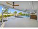 A covered patio with outdoor seating, ceiling fans, and a view of the landscaped backyard at 1029 Bal Harbour Dr, Apollo Beach, FL 33572