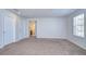 Spacious bedroom with neutral carpet and natural light from a window, showcasing ample room and two doors at 11117 Abaco Island Ave, Riverview, FL 33579