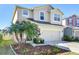Two-story home with an attached two-car garage and a well-kept yard with multiple palm trees at 11117 Abaco Island Ave, Riverview, FL 33579