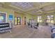 Spacious gym includes various exercise machines and weights, all with ceiling fans at 11117 Abaco Island Ave, Riverview, FL 33579