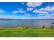 Expansive lake view from the community's green space, under a vast, partly cloudy sky at 11117 Abaco Island Ave, Riverview, FL 33579