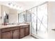 Bright bathroom featuring a double sink vanity with dark wood cabinets and a glass-enclosed shower at 11539 Tangle Branch Ln, Gibsonton, FL 33534