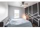 Cozy bedroom featuring a decorative accent wall, ceiling fan, and a large window at 11539 Tangle Branch Ln, Gibsonton, FL 33534