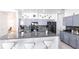 Well-lit kitchen featuring granite counters, stainless steel appliances, tile floors, a large island with seating, and stylish cabinetry at 11539 Tangle Branch Ln, Gibsonton, FL 33534