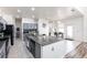 Well-lit kitchen featuring granite counters, stainless steel appliances, tile floors, a large island with seating, and stylish cabinetry at 11539 Tangle Branch Ln, Gibsonton, FL 33534