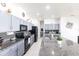 Well-lit kitchen featuring granite counters, stainless steel appliances, tile floors, a large island with seating, and stylish cabinetry at 11539 Tangle Branch Ln, Gibsonton, FL 33534