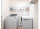 This laundry room features a modern, white washer and dryer and wire shelving for added storage at 11539 Tangle Branch Ln, Gibsonton, FL 33534
