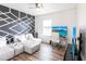 Bright room featuring a decorative accent wall, white sofa and a desk with a computer at 11539 Tangle Branch Ln, Gibsonton, FL 33534