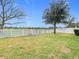 Spacious backyard with green grass, mature trees and a white picket fence at 12222 Legacy Bright St, Riverview, FL 33578