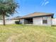 The backyard features a cozy patio and a manicured lawn surrounded by a white fence at 12222 Legacy Bright St, Riverview, FL 33578