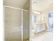 This primary bathroom features a glass shower, double sink vanity and tile flooring at 12222 Legacy Bright St, Riverview, FL 33578