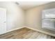 A bright bedroom features modern wood-look floors, a window and neutral paint, creating a calming atmosphere at 12222 Legacy Bright St, Riverview, FL 33578