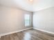 A bright bedroom features modern wood-look floors, a window and neutral paint, creating a calming atmosphere at 12222 Legacy Bright St, Riverview, FL 33578