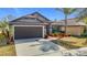 Charming single-story home with a two-car garage, stone accents, manicured lawn, and a welcoming entryway at 12222 Legacy Bright St, Riverview, FL 33578