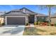 Charming single-story home with a two-car garage, stone accents, manicured lawn, and a welcoming entryway at 12222 Legacy Bright St, Riverview, FL 33578