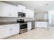 Updated kitchen features stainless appliances, white cabinets, and granite counters at 12222 Legacy Bright St, Riverview, FL 33578