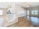 Open floor plan with wood-look floors, white kitchen, and plenty of natural light at 12222 Legacy Bright St, Riverview, FL 33578