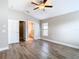 A bright main bedroom features modern wood-look floors, a ceiling fan, and neutral paint at 12222 Legacy Bright St, Riverview, FL 33578