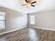 A bright main bedroom features modern wood-look floors, windows and neutral paint at 12222 Legacy Bright St, Riverview, FL 33578