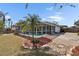 Lush backyard with a large screened in pool, ample deck area, and an array of tropical landscaping at 12806 Yarn Pl, Riverview, FL 33569