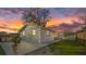 Exterior view of the home with a backyard patio, above-ground pool, and spacious yard under a vibrant sunset sky at 1315 E Dr Martin Luther King Jr Blvd, Plant City, FL 33563