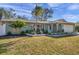 Inviting one-story home featuring a light-colored exterior, a well manicured lawn, and lush, tropical landscaping at 13330 88Th Pl, Seminole, FL 33776