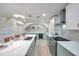 Well-lit kitchen boasting white countertops, stainless steel appliances, stylish lighting, and a center island with seating at 13330 88Th Pl, Seminole, FL 33776