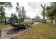 Spacious backyard with a wooden deck, a variety of trees, and space to park trailers at 1773 Ezelle Ave, Largo, FL 33770