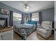 Comfortable bedroom with light blue walls, two windows and a comfortable recliner at 1773 Ezelle Ave, Largo, FL 33770