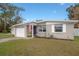 Quaint single-story home with well-kept lawn and a patriotic American flag flying near the entrance at 1773 Ezelle Ave, Largo, FL 33770