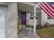 Home entrance with vibrant purple door, potted plants, and the American flag on display at 1773 Ezelle Ave, Largo, FL 33770