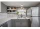 Close-up of the kitchen sink area with white countertops and stainless steel appliances at 1773 Ezelle Ave, Largo, FL 33770