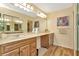 Bathroom with double sinks, wood cabinets, and large mirror at 1801 E Lake Rd # 11A, Palm Harbor, FL 34685