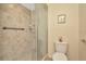 Bathroom featuring tile shower with glass door, grab bar and neutral colored walls and fixtures at 1801 E Lake Rd # 11A, Palm Harbor, FL 34685