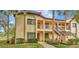 Inviting two-story condo showcases a charming facade with palm trees and well-maintained landscaping at 1801 E Lake Rd # 11A, Palm Harbor, FL 34685